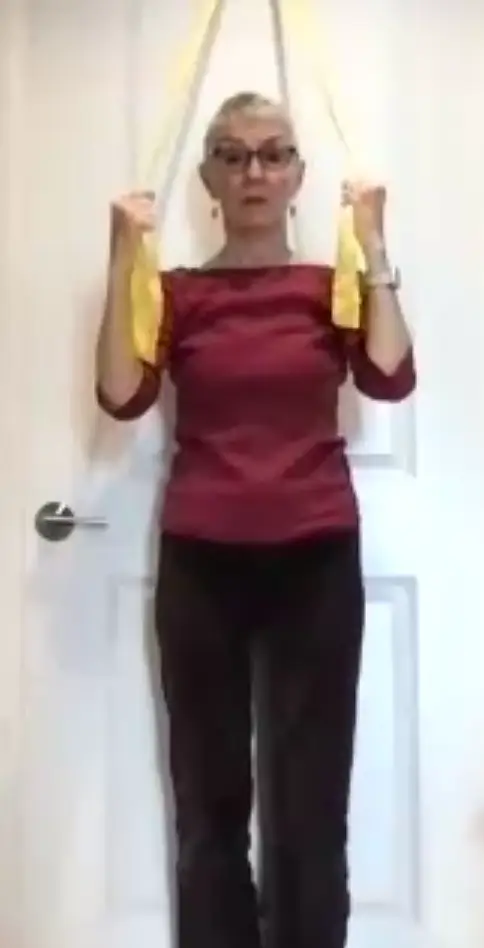 Jean does arm exercises against the wall.