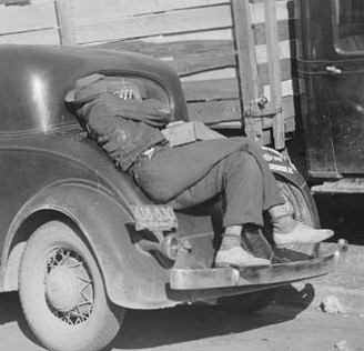 person sleeping on their car on their back